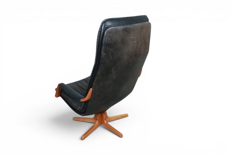 Back view of Arne Wahl Iversen black leather highback swivel chair and ottoman — 1970s Danish