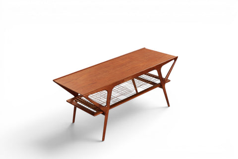 Three-quarter view of Danish teak coffee table with cane shelf — 1950s Scandinavian modern