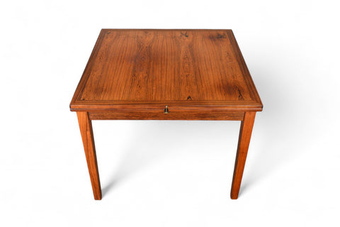 A square-shaped, rosewood dining table with a flip-top lid positioned on a plain background.