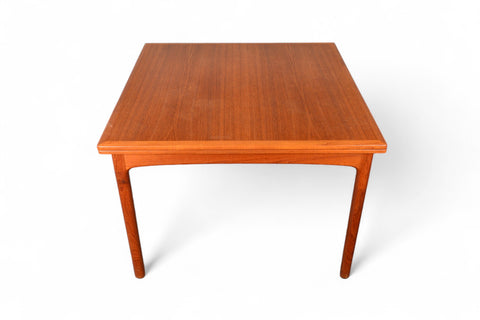 Top-down angle of a teak expandable table, ready to open for additional dining space