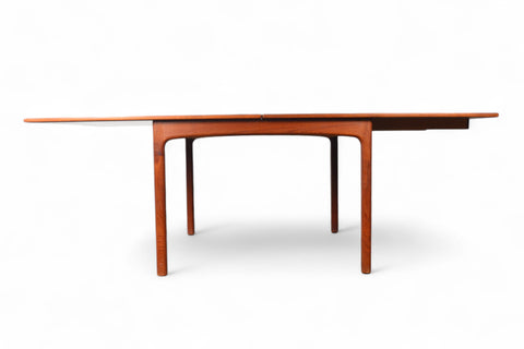 Side profile of an extendable teak table, flip section neatly stowed