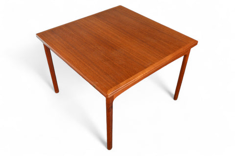 Closed teak table with hinged top, streamlined silhouette for smaller spaces