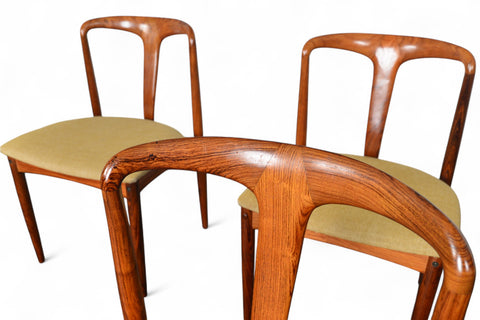 Three wooden chairs with beige seats on a white background
