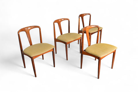 Four wooden chairs with beige cushions on a white background