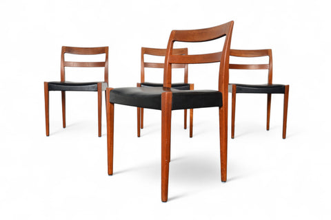 Four wooden chairs with black leather seats on a white background