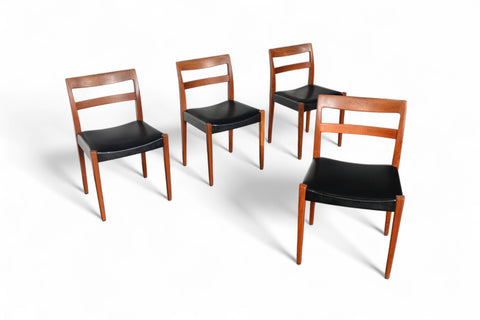 Four wooden chairs with black seats on a white background