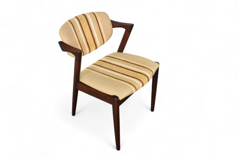 Wooden chairs with striped cushions on a white background