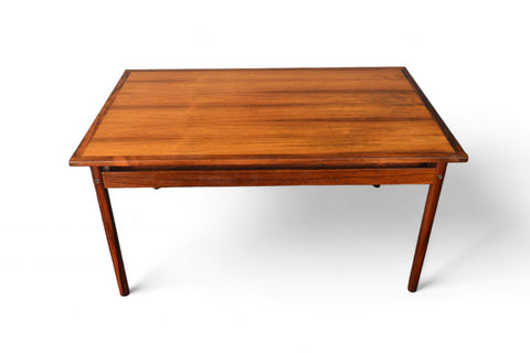 Close-up of richly figured rosewood tabletop with smooth edges and concealed extension leaves.