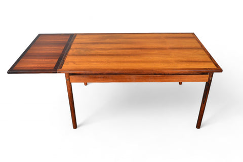 Top-down view of a rosewood dining table, compact with leaves neatly tucked away.