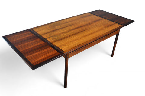 Angled view highlighting the richly patterned rosewood surface and built-in extension leaves.