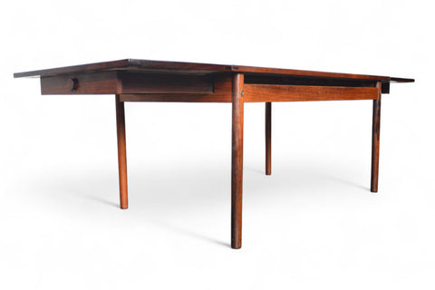 Expandable rosewood dining table, smooth profile with hidden leaves stored within.
