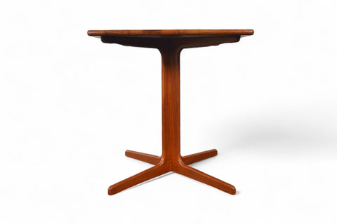 Side profile of solid teak small pedestal table highlighting pedestal base.