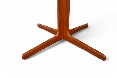 Close-up of solid teak grain on small pedestal table surface.