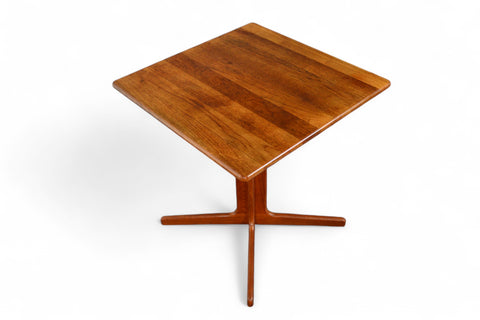 Solid teak small pedestal table in mid-century modern dining setting.